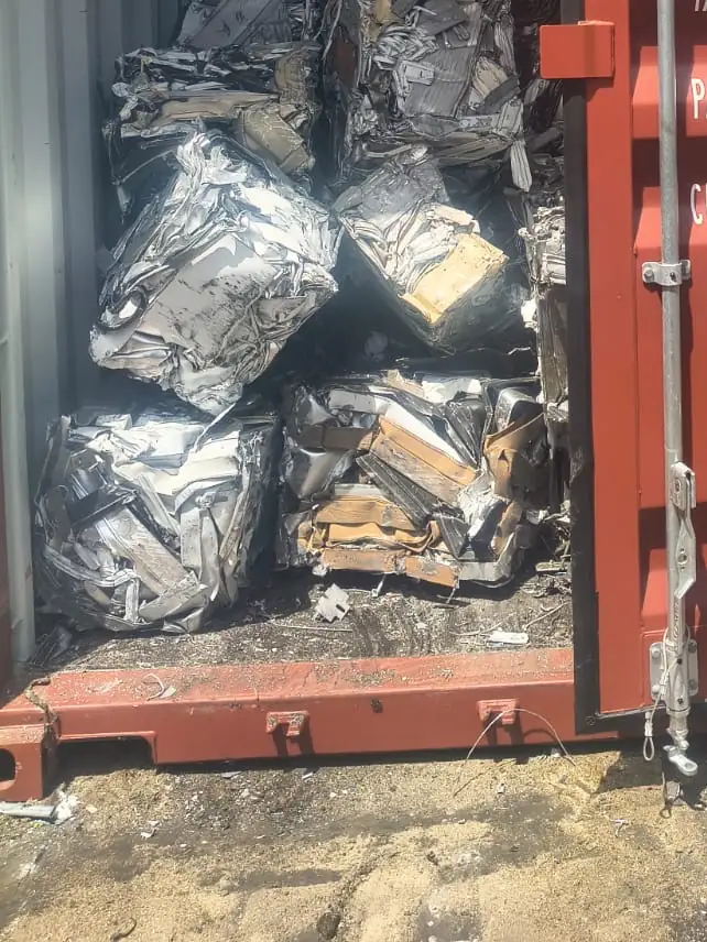 Container door open on stacked bales of aluminium
