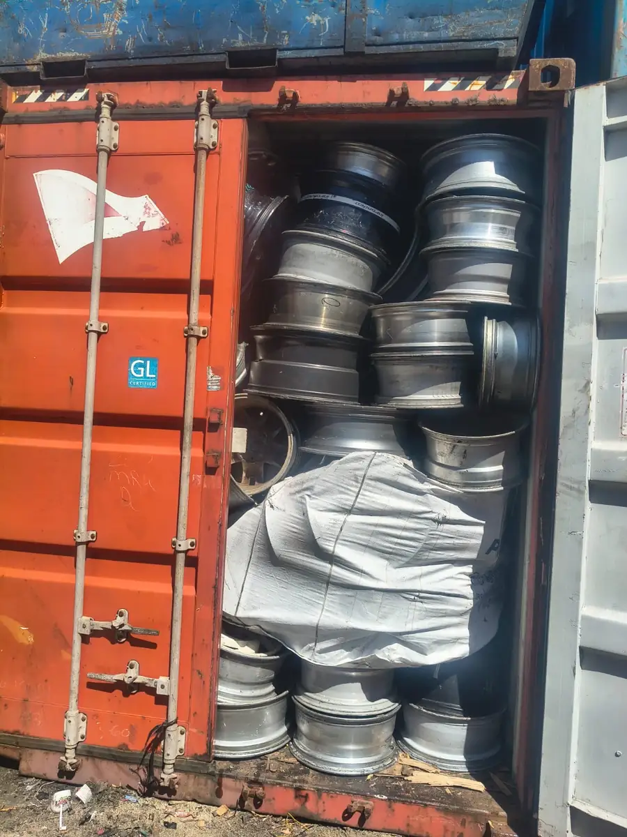 Container door open on stacked aluminium wheels and a bulka bag