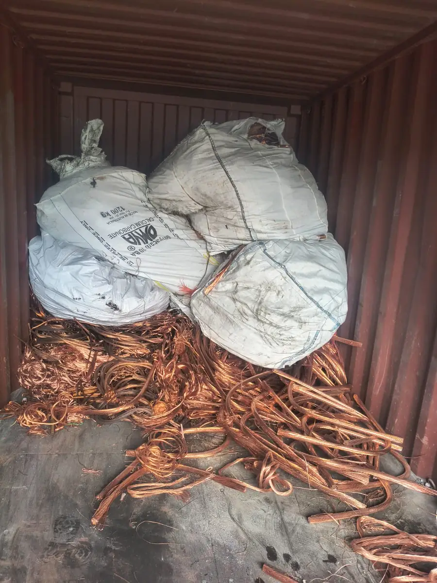 Copper tube in a shipping container, with bulka bags stacked behind it