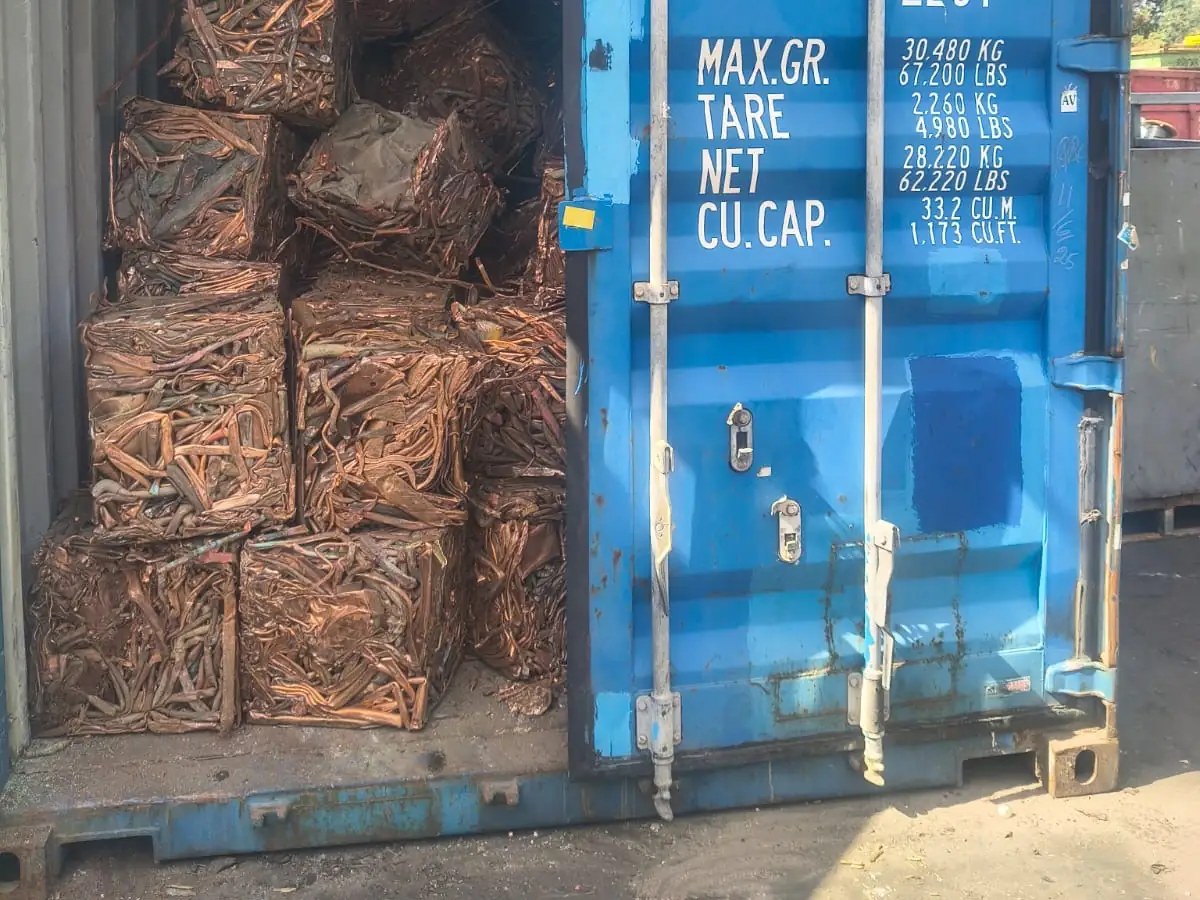 Shipping container at the Ingleburn yard, door open on stacked bales of copper ready for export